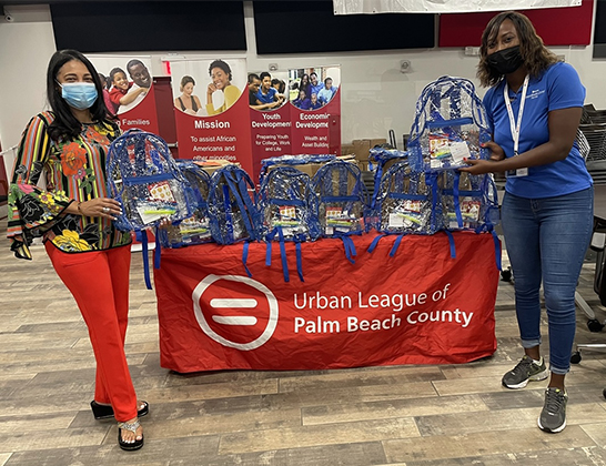 Rachel McNair, coordinator, Community Programs & Communications for AmeriHealth Caritas Florida, presents a donation of backpacks with school supplies to Urban League of Palm Beach County (ULPBC) Vice President of Development and Communications Soulan Johnson.